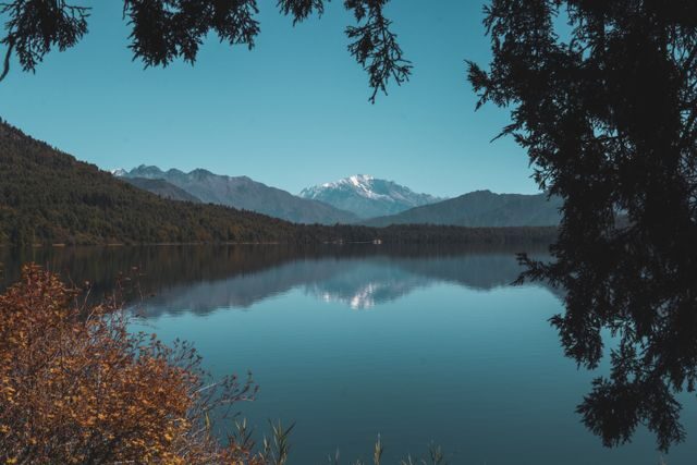 Deep blue Rara Lake ringed by pine forest and snow-dusted ridges in far-western Nepal